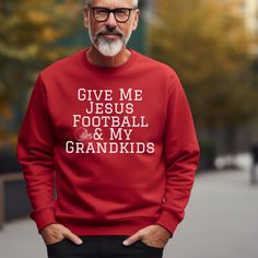 an older man wearing a red sweatshirt that says give me jesus football and my grandkids