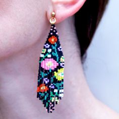 These wildflower fringe earrings will liven up your outfit for sure! The colorful flowers pop off the background color making them a statement accessory but they are equally easy to dress down with jeans and a t-shirt. Handwoven with Japanese Miyuki glass beads they are truly unique. They are lightweight and the stainless steel ball post helps the earrings to stay put on your earlobe. These earrings are designed by myself and made in conjunction with my team of women artisans from vulnerable com Multicolor Beaded Flower Earrings For Spring, Spring Multicolor Beaded Flower Earrings, Trendy Spring Jewelry With Fringe, Bohemian Fringe Earrings For Spring, Bohemian Beaded Flower Earrings For Spring, Spring Bohemian Beaded Dangle Earrings, Spring Bohemian Fringe Earrings, Spring Multicolor Beaded Earrings, Spring Bohemian Beaded Flower Earrings