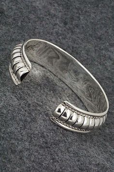 This beautiful, brightly polished sterling silver bracelet was made by Navajo silversmith Manuel Johnson. The inside is signed MJ and stamped sterling.Size: 5 5/8" (will fit up to a 6 5/8" wrist)Gap: 1"Width: 5/8"Free shipping on all orders! We ship with USPS and always include tracking. All orders ship within a day of payment.Returns are accepted up to 30 days after you receive your order. Just send us a message. Our shop offers cash back or store credit. The item must be returned in new condit Luxury Adjustable Southwestern Sterling Silver Bracelet, Silver Southwestern Style Cuff Bracelet For Formal Occasions, Southwestern Sterling Silver Polished Bangle Bracelet, Adjustable Silver Southwestern Bangle, Southwestern Sterling Silver Bangle With Polished Finish, Southwestern Polished Sterling Silver Bangle, Adjustable Southwestern Silver Bangle, Artisan Sterling Silver Bangle Bracelet, Southwestern Silver Bangle Jewelry