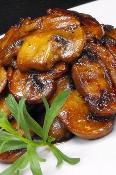 a white plate topped with fried bananas and green garnish on top of it