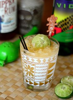 an alcoholic drink with limes on the table