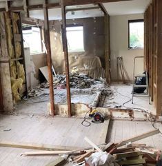 an unfinished room with wood flooring and walls that have been torn off from the house