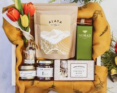 a gift hamper filled with food and flowers