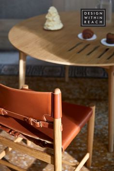 a brown leather chair sitting in front of a table with desserts on top of it