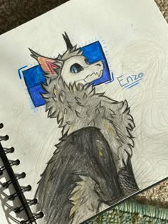 a drawing of a dragon with an eye patch on it's head, sitting next to a notebook