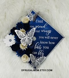 a blue graduation cap with white flowers and butterflies on it, that says until you read your wings you will never know how far you can fly