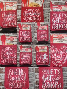 red bags with white lettering on them are hanging up against a brick wall in the shape of christmas baking