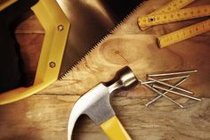 tools on wooden table with measuring tape and screwdrivers, hammers and nails