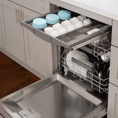 an open dishwasher with dishes in it