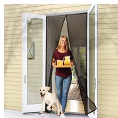 a woman holding a tray of food and standing next to a dog on the porch