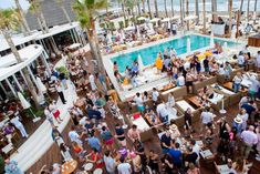 a crowd of people standing around a swimming pool