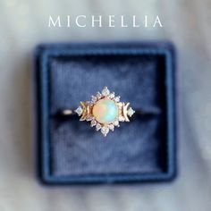 an opal and diamond ring in a velvet box with the name michella on it