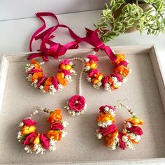 four bracelets with flowers and ribbons on a tray