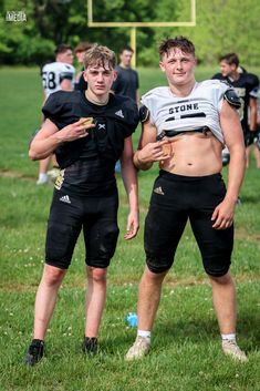 two young men standing next to each other on a field