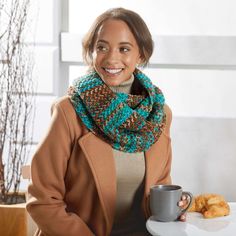 a woman sitting at a table holding a coffee cup