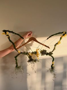 a person's hand hanging from the side of a wall with flowers on it