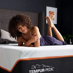 a woman laying on top of a tempur - pedic mattress