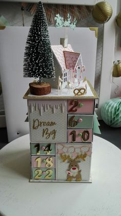 a doll house made out of different types of items on a table with decorations around it