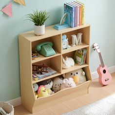 a book shelf with stuffed animals and books on it in a child's room