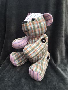 a plaid teddy bear sitting on a black background