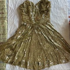 Please Do Not Message Me With Questions That Are In The Description Or If You Do Not Intend On Buying. Gold Sequin Badgley Mischka Mini Cocktail Dress. Excellent Condition. Size 2. This Dress Is Strapless And Has A Beautiful Made Sewn-In Bodice, Hidden Zipper And Fully Lined. Hits Right At The Knee Or Just Above. There Is No Stretch At The Waist. Waist Measurement Is 13” Flat. Length From Armpit To Hem Is Approximately 28”. Mannequin Is Tall (With Hips) And Dress Does Not Zipper On The Mannequin (See Photos). See Last Two Photos Of The Only Two Teeny Tiny Snags That Are Barely Noticeable, Both At The Back Of The Dress. If You Cannot See Them That’s Because They’re Not Noticeable. Th Formal Gold Mini Dress With Sequins, Gold Dressy Mini Dress For Cocktail, Gold Dressy Cocktail Mini Dress, Gold Mini Dress With Sweetheart Neckline For Evening, Glamorous Holiday Silk Dress, Holiday Glamorous Silk Dress, Brown Sparkly Dress, Buying Gold, Sparkly Dress