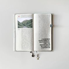 an open book sitting on top of a table next to a pair of ear buds