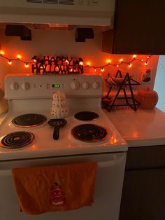 a white stove top oven sitting inside of a kitchen next to a wall covered in lights