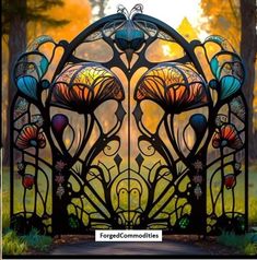 an ornate iron gate in the middle of a park with trees and grass behind it