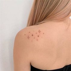 the back of a woman's shoulder with small stars on her left arm and chest