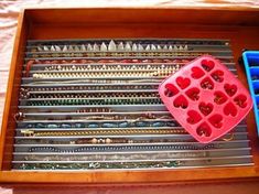 a wooden tray with many different types of beads in it