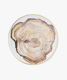 a white and gold plate with a tree stump design on the rim, against a white background