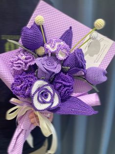 a bouquet of purple crocheted flowers in a vase