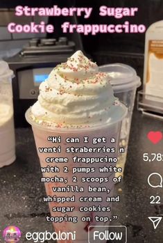 a cup filled with whipped cream and sprinkles on top of a counter