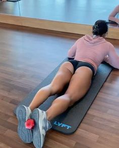 a woman laying on a yoga mat with her legs crossed