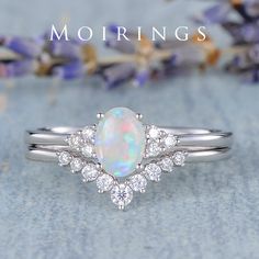 a white opal and diamond ring with the words mornings above it, on a blue background