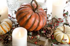 a table topped with candles and pumpkins