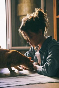 a woman sitting at a table petting a cat with caption that reads, some of my best friends never say word to me