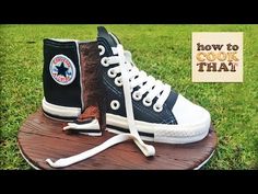 a pair of black and white shoes sitting on top of a wooden board in the grass