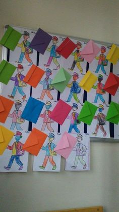 a bulletin board with many different colored papers on it and people drawn on the wall