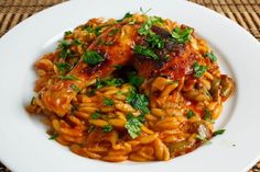 a white plate topped with pasta and meat