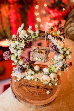 a wooden stand with flowers and a birdcage on it