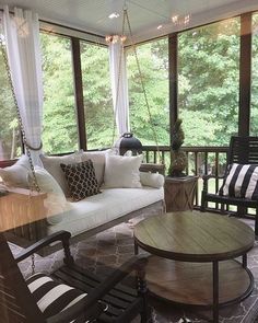 a porch with chairs, table and couches on it