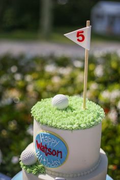 a birthday cake with golf balls and a flag on top