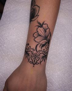 a black and white flower tattoo on the arm