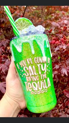 a person holding up a green drink in front of some leaves and bushes with the words, i love my corona salty bring the tequila