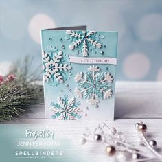 a card with snowflakes on it sitting next to some beads and christmas decorations