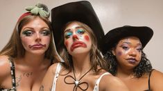 three beautiful women with face paint posing for the camera