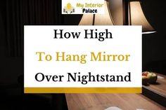 a table with a lamp and some papers on it that says how high to hang mirror over nightstand