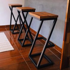 three stools sitting on top of a wooden floor