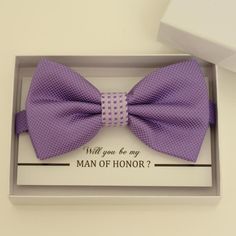 a purple bow tie in a box with the words will you be my man of honor?